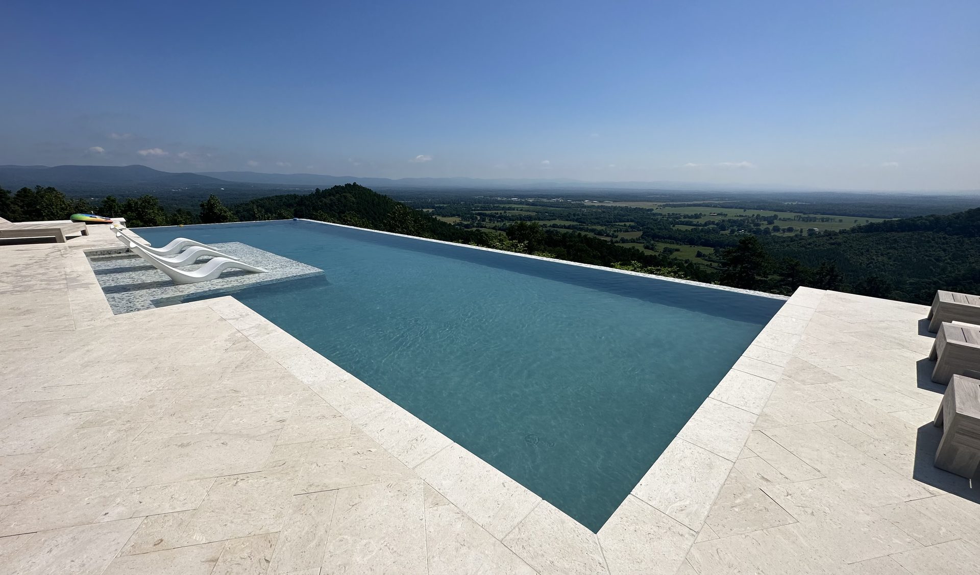 Custom gunite pool and deck on a bright summer afternoon